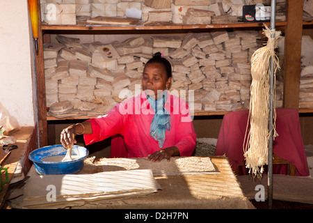 Madagascar, Ambalavao, woman pasting covers of Antaimoro Avoha hand made paper book Stock Photo