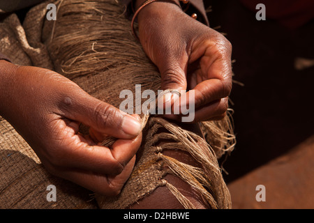 Madagascar, Ambalavao, Soalandy Silk Workshop, hands of worker tying silk scarf fringe Stock Photo