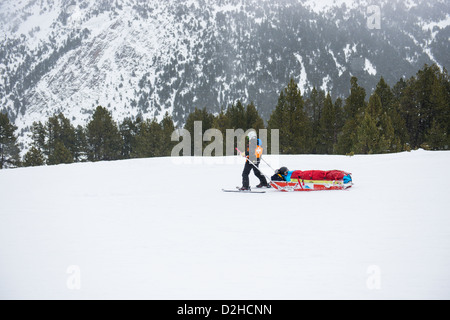 Alpine Ski Rescue in the Pyrenees mountains of Andorra. An injured skier returns to the medical centre via a snow patrol medic strapped into a sled. Stock Photo