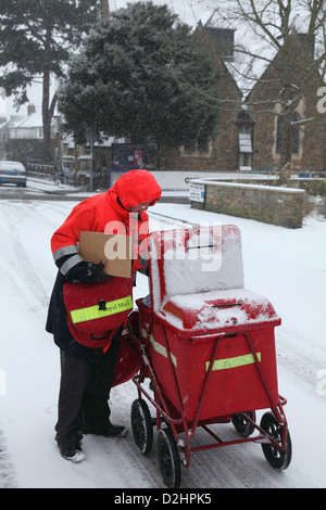 Postman delivers the mail in London in a January snowfall. Stock Photo