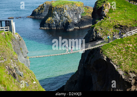 People crossing Carrick-a-rede Rope Bridge, County Antrim, Northern Ireland. Stock Photo