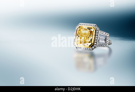 Yellow Canary Diamond Ring on blue silver background Stock Photo