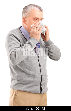 Mature man blowing his nose in a tissue isolated on white background Stock Photo