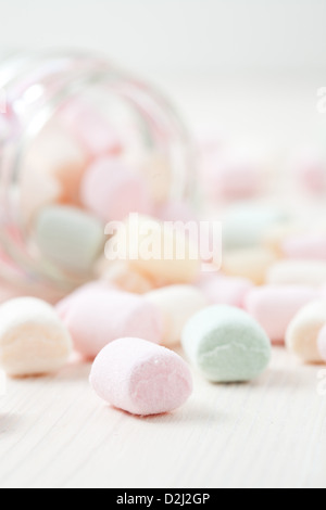 Colorful marshmallows in glass jar on light background Stock Photo