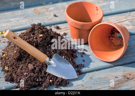 Soil and trowel to fill two empty clay pots. Stock Photo
