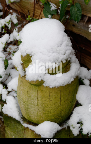 Snow covered stone pig garden ornament gnome Stock Photo