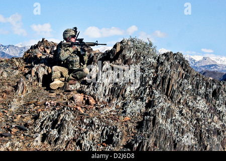 A US Army watches a valley for insurgents from a mountaintop outside the village of Nengaresh, Nuristan Province, Afghanistan January 21, 2011. Stock Photo