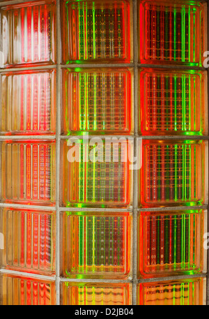 Curved glass brick wall lit from behind with red and green neon lights Stock Photo