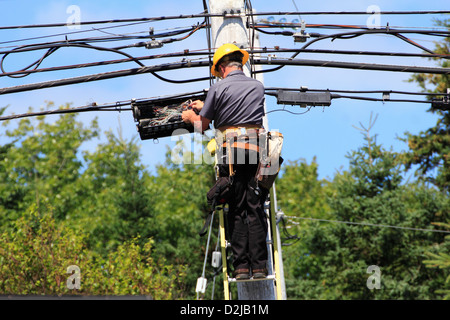A telephone linesman working on circuits at a telephone pole Stock Photo