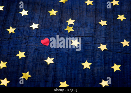 Shiny gold stars and red love heart on a blue wood background Stock Photo
