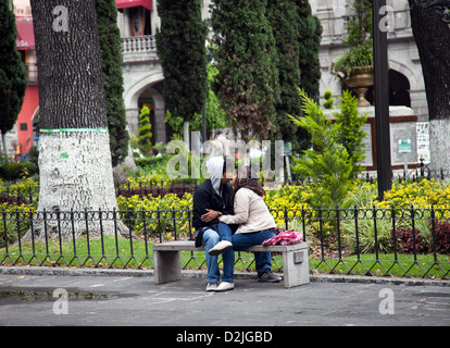 Romantic Couple on Bench on Zocalo in Puebla in Mexico Stock Photo