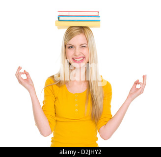 Student girl in yoga pose with books on head Stock Photo