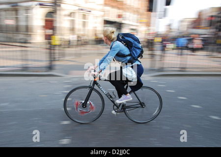girl cycling through Camden High Street London UK Stock Photo