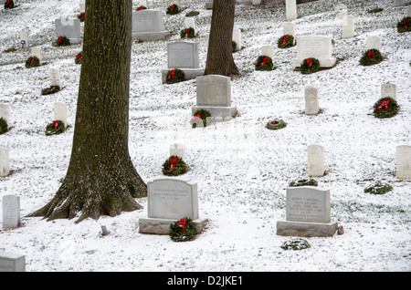 Headstones at Arlington National Cemetery in the snow. Volunteers have added a holiday wreath to each gravesite. Arlington, Virginia, United States. Stock Photo