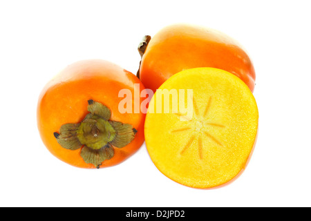 Three kaki fruits, one cut in half against white background