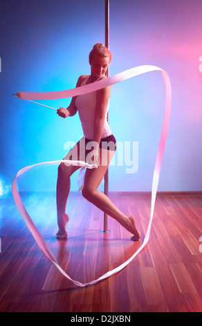 Young pole dance woman with ribbon. Stock Photo