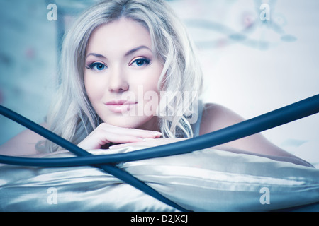Young woman in bed. White and blue colors.