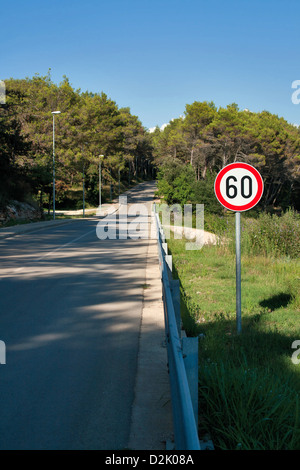 Countryside road by forest, 60 speed limit sign Stock Photo