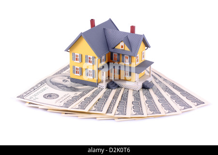 Miniature house over money isolated on white background Stock Photo