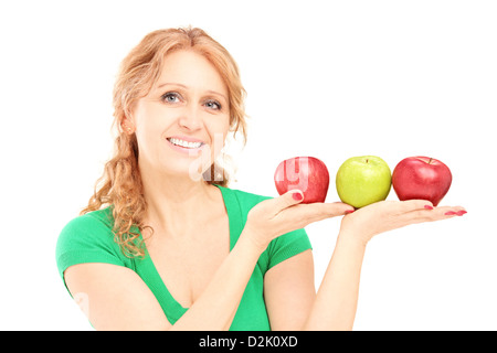Mature beautiful woman sitting and holding three apples isolated on white background Stock Photo