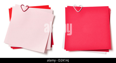 pink and red sticky notes with paper clip in shape of heart on white background Stock Photo