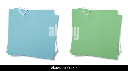 blue, green and white sticky notes with paper clip in shape of heart on white background Stock Photo
