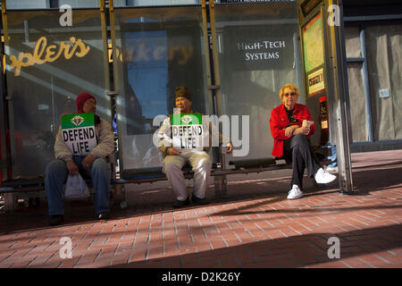 San Francisco. Jan 26th, 2013. Pro life supporters take a rest at a bus stop on Market Street during the west coast 'walk for life' rally in San Francisco January 26, 2013. Stock Photo