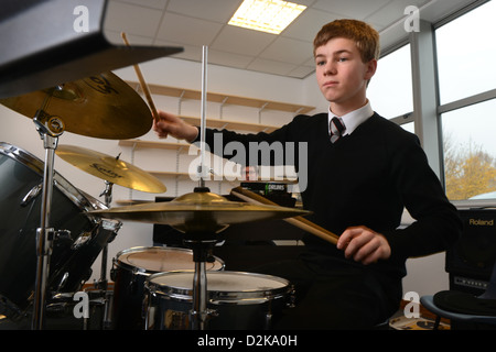 A school boy drumming in a music lesson at Pates Grammar School in Cheltenham, Gloucestershire UK Stock Photo