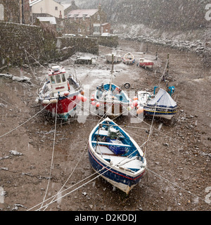 Heavy snow over cobble fishing boats at low tide, in the fishing village of Staithes. Stock Photo