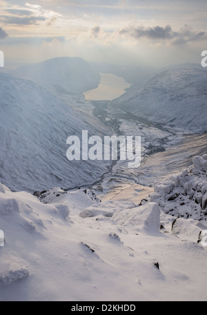 View over Wasdale and Wast Water from next to the Westmorland Cairn on the summit of Great Gable in winter in the English Lakes Stock Photo