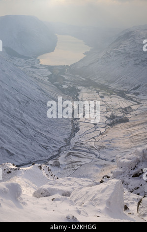 View over Wasdale and Wast Water from next to the Westmorland Cairn on the summit of Great Gable in winter in the English Lakes Stock Photo