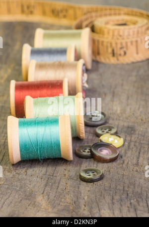 Buttons and measuring tape with spools of thread Stock Photo