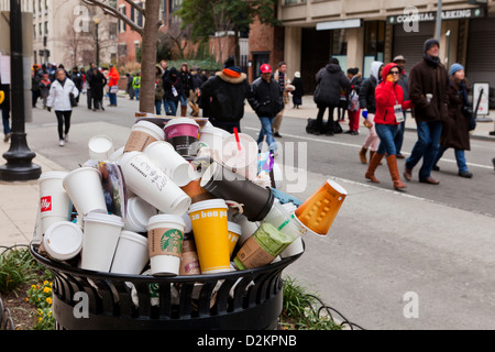 Discarded coffee cups overflowing from public trash bin - USA Stock Photo