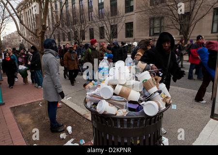 Discarded coffee cups overflowing from public trash bin Stock Photo