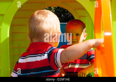 Two little brothers playing in the playhouse. Stock Photo