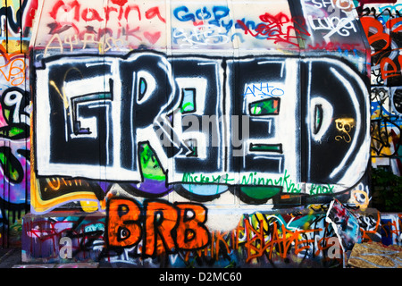 wall of graffiti with greed in large letters Stock Photo