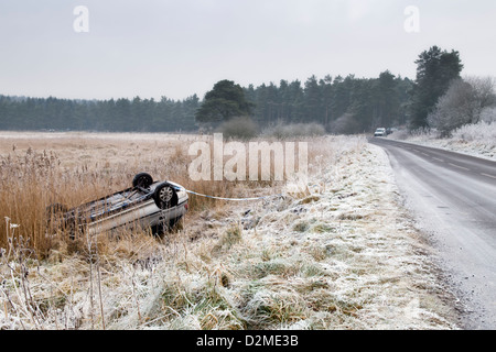 Upturned car from road traffic accident after a thick hoar frost on a winding country road in Priddy Somerset Stock Photo