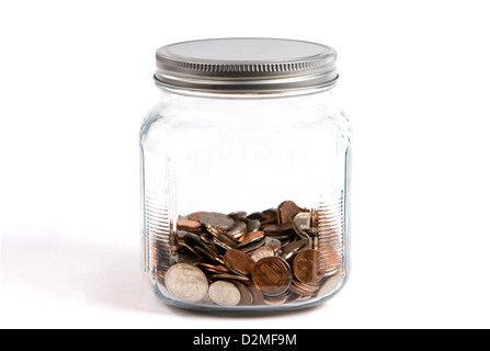 Spare change jar or piggybank holds coins in a glass container on white background. Stock Photo