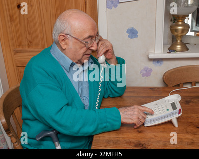 elderly man using telephone at home Stock Photo