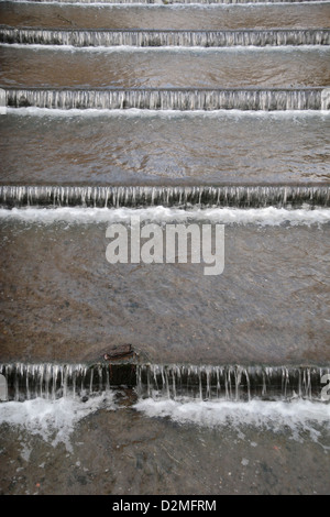 Fast flowing water over a series of waterfalls on a weir in Bushy Park, UK (close to the Upper Lodge & Brew House). Stock Photo