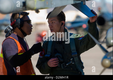 Airmen from the Republic of Singapore Air Force assigned to the 425th Fighter Squadron at Luke Air Force Base, Ariz., inspect an F-16 Fighting Falcon during RED FLAG 13-2 Jan. 21, 2013, at Nellis Air Force Base, Nev. During the two year assignment, they r Stock Photo