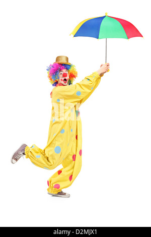 Full length portrait of a male clown with umbrella isolated on white background Stock Photo