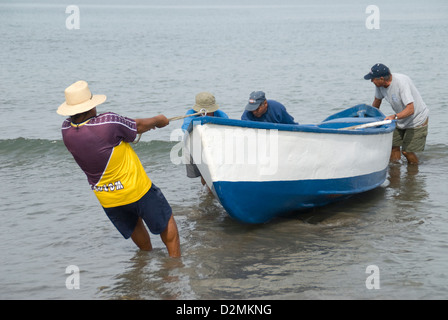 Panga fishermen landing boat on beach at Mazatlan,Mexico. Stock Photo