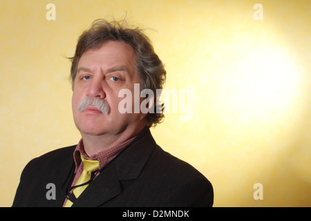 Handsome middle age business man wearing a suit on a yellow background Stock Photo