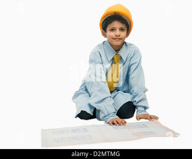 Boy dressed as an architect and working on a blueprint Stock Photo