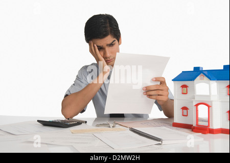 Real estate agent reading a document near a model home Stock Photo
