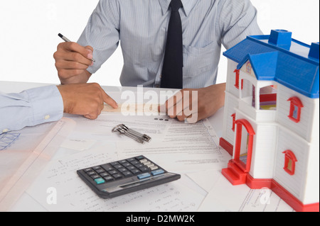 Real estate agent discussing a document with a customer Stock Photo