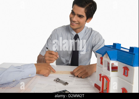 Real estate agent discussing a document with a customer Stock Photo