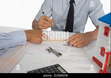 Real estate agent discussing a document with a customer Stock Photo