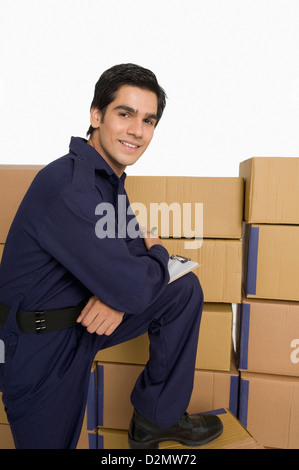 Portrait of a store incharge standing near cardboard boxes and smiling Stock Photo